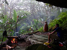 Man sitting in shelter looking at jungle.